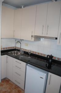 a kitchen with white cabinets and a sink at Centro de Granada in Granada
