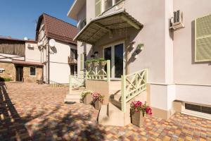 a house with a gate and flowers in a courtyard at Mini Hotel Ryleev in Kharkiv