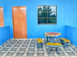 a blue room with a table and two chairs at D'pinggir Guest Room in Kuala Tahan