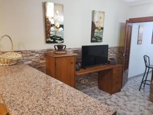 a living room with a television on a wooden cabinet at Casa Ignacio in Arriate