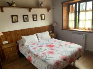 1 dormitorio con 1 cama con colcha de flores en Apartemento Aiguestortes en Pla de l'Ermita