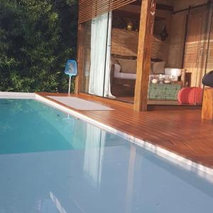 a swimming pool with a view of a room with a couch at Villa Piccolo Di Mare in Ilhabela