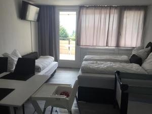 ein Zimmer mit zwei Betten und einem Tisch und einem Fenster in der Unterkunft Ferienwohnung Reinhold im Predigtstuhl Resort in Sankt Englmar + 16 Fotos