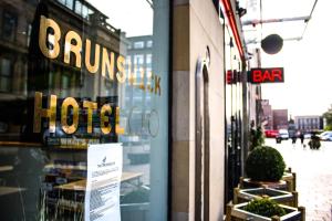 a window of a store with a sign on it at Brunswick Merchant City Hotel in Glasgow