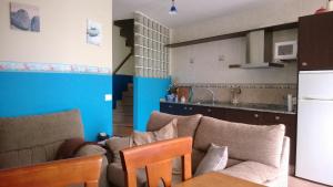a living room with a couch and a kitchen at Apartamentos Turisticos As Cetareas in Rinlo