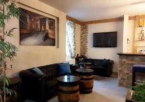 a living room with a couch and a tv at Hotel Geismar in Göttingen