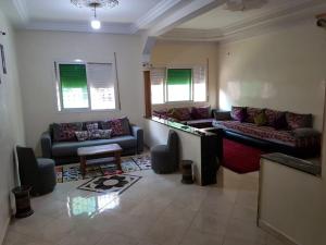 uma sala de estar com dois sofás e uma mesa em Joli Appartement Meublé à Rte Ain Chkef em Fez