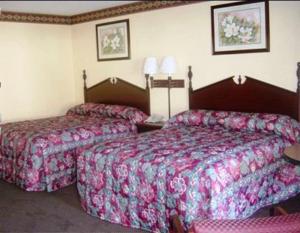 a hotel room with two beds and two lamps at Scottish Inn Maggie Valley in Maggie Valley