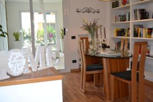 una zona pranzo con tavolo e sedie e una sala da pranzo di Casa La Rosa a Montegrotto Terme