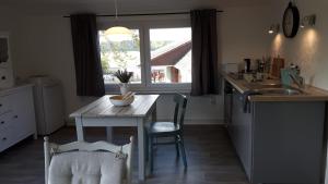 eine Küche mit einem Tisch, einem Waschbecken und einem Fenster in der Unterkunft Ferienwohnung an der Südheide 80 qm max 4 Personen in Dedelstorf