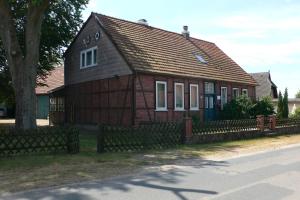 ein braunes Haus mit einem Zaun davor in der Unterkunft Ferienwohnung an der Südheide 80 qm max 4 Personen in Dedelstorf
