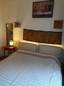 ein großes Bett in einem Schlafzimmer mit einer Lampe auf einem Tisch in der Unterkunft Casamia in Bologna