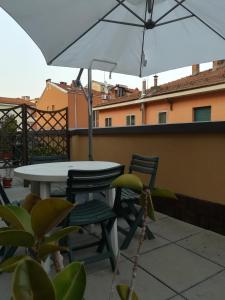 einen Tisch, Stühle und einen Regenschirm auf dem Balkon in der Unterkunft Casamia in Bologna