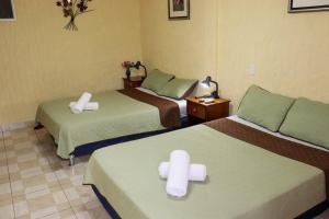 Habitación de hotel con 2 camas y toallas blancas. en Hotel Valle Verde, en El Valle de Antón