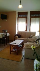 sala de estar con sofá y mesa en Apartamentos Turisticos As Cetareas, en Rinlo