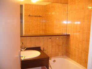 a bathroom with a sink and a bath tub at Fontaines Blanches 320 in Avoriaz