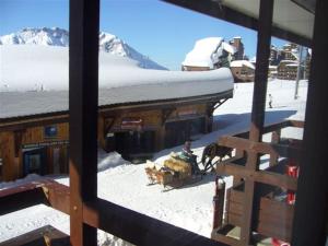 um grupo de animais a puxar um trenó em frente a um edifício em Fontaines Blanches 320 em Avoriaz