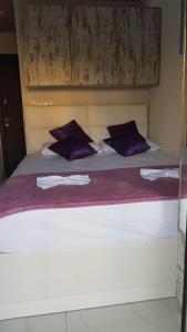 パラリア・カテリニスにあるD&B Studio 2の紫色の枕が付いた大きな白いベッド