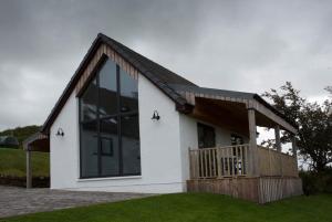 a small white house with a large window at Creag Moine Luxury Self Catering in Kensaleyre