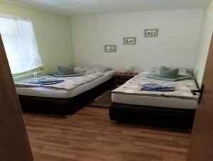 2 camas individuales en una habitación con ventana en Ferienhaus Hüfler 59 en Kelbra