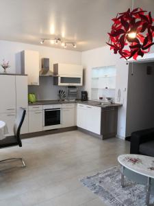 a kitchen with white cabinets and a red chandelier at Ferienwohnung Winzer in Annaberg-Buchholz