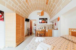 Cet appartement comprend une chambre avec un lit et une cuisine avec une table. dans l'établissement Terra di Leuca, à Salve