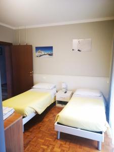 a room with two beds and a desk at l'igloo b&b in Sedico