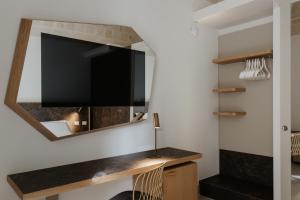 a living room with a tv and a mirror at Euvodia Luxury Rooms in Matera