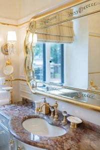 W łazience znajduje się umywalka i lustro. w obiekcie Villa Luttwitz w Baden-Baden