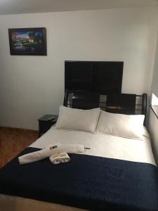 a bedroom with a bed with two towels on it at Hotel Casa Paulina in Bogotá