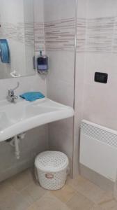 a white bathroom with a sink and a toilet at PHOENIX HOSTEL in Valprato Soana