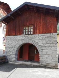 a building with a red door and an archway at PHOENIX HOSTEL in Valprato Soana