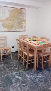 a dining room table with chairs and a map on the wall at PHOENIX HOSTEL in Valprato Soana