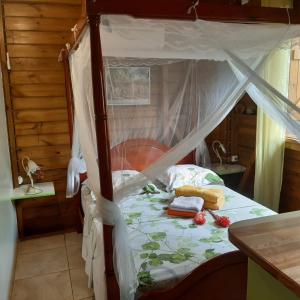 a bedroom with a bed with a canopy at Le Filao in Pointe-Noire