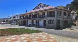 un antiguo edificio al lado de una calle en Hosteria Iloca, en Iloca