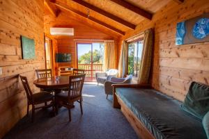 um quarto com uma mesa e uma sala de jantar em Ocean View Chalets em Marahau