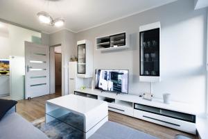 een woonkamer met een witte tafel en een tv bij Apartament T.LOVE NOVA 2 in Szczecin