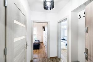 a hallway with white walls and a door and a room at Apartament T.LOVE NOVA 2 in Szczecin