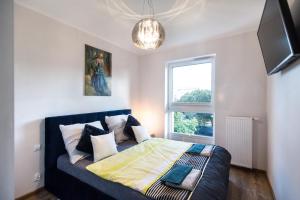 een slaapkamer met een bed en een raam bij Apartament T.LOVE NOVA 2 in Szczecin