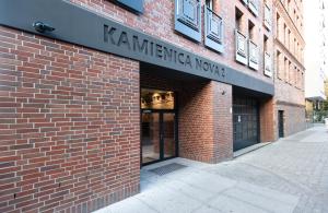 een bakstenen gebouw met een bord waarop staat 'kaminica workshop' bij Apartament T.LOVE NOVA 2 in Szczecin