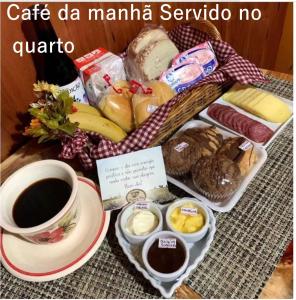 una bandeja de comida y una taza de café y pan en Chalé Temático em Pipa de Vinho - Parada da Pipa Chalés, en Canela