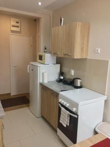 a kitchen with a white stove and a refrigerator at Home in Zalaegerszeg