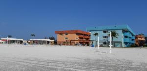 ein Gebäude am Strand mit Palmen und Eigentumswohnungen in der Unterkunft GOLDEN LAKE RESIDENCE in Arraial do Cabo