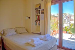 een slaapkamer met een bed met twee handdoeken erop bij Sunny Top Floor Studio - Excellent Athens view in Athene
