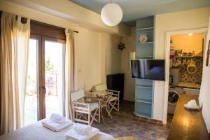 een woonkamer met een televisie en een tafel met stoelen bij Sunny Top Floor Studio - Excellent Athens view in Athene