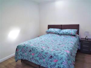 a bedroom with a bed with a blue comforter at 67c The Mews in Newport