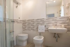 W łazience znajduje się umywalka, toaleta i lustro. w obiekcie B&B La Casa di Otello w mieście Carmignano