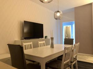ein Esszimmer mit einem Tisch mit Stühlen und einem TV in der Unterkunft Ca Re Vespucci in Pordenone