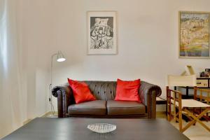 a living room with a brown couch and red pillows at Apartamento Centrum Córdoba con Parking in Córdoba