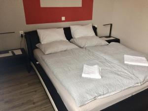 Una cama grande con dos toallas blancas. en Home en Zalaegerszeg